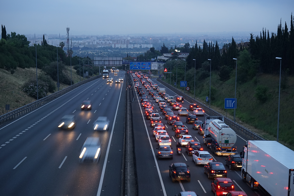  Movilidad residencia-trabajo en la aglomeraci&oacute;n urbana de Sevilla (autov&iacute;a A-49 a la altura de la cornisa del Aljarafe)
La movilidad define hoy al habitante metropolitano. Los flujos cotidianos entre el lugar de residencia y trabajo generan un movimiento pendular continuo, que ha dado pie incluso a un vocablo propio: el commuter, entendido como la persona que realiza a diario estos desplazamientos. Si a ello sumamos un modelo enormemente dependiente del transporte privado motorizado por excelencia &mdash;el coche&mdash;, el resultado es visiblemente contundente: una afluencia asim&eacute;trica de coches que colapsan las carreteras al amanecer, desde las periferias residenciales al centro de la ciudad donde se localizan los puestos de trabajo; y el correspondiente atasco de vuelta a casa, al atardecer, en el sentido contrario. La fotograf&iacute;a, que capta el &ldquo;atasco del Aljarafe&rdquo; a primera hora de la ma&ntilde;ana en la autov&iacute;a A-49, suscita algunos interrogantes: &iquest;Qu&eacute; sensaciones y sentimientos experimentan las personas que pasan todos los d&iacute;as entre media y una hora parados en sus coches en medio de esa autov&iacute;a? &iquest;Es prioritario para la pol&iacute;tica de Ordenaci&oacute;n del Territorio mitigar los efectos de este modelo de movilidad? &iquest;Qu&eacute; papel juegan en todo ello los fabricantes de coches?